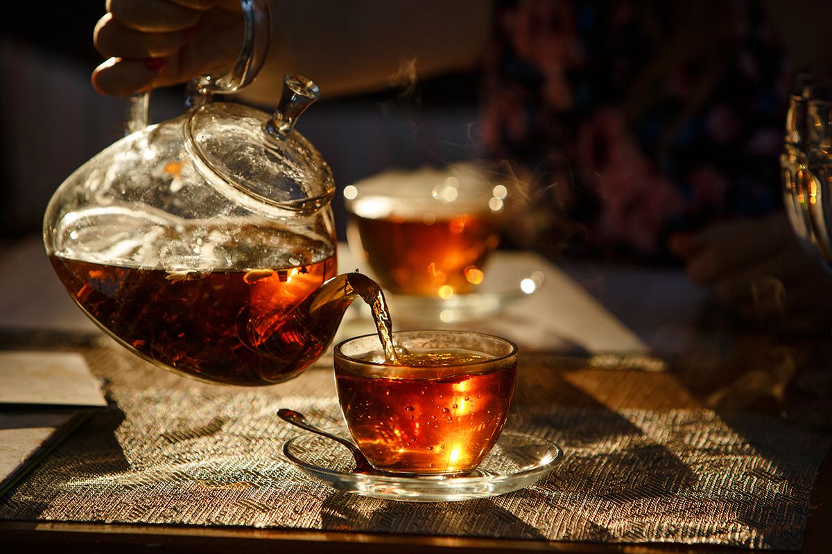 Image of a glass teapot on a wooden bench.